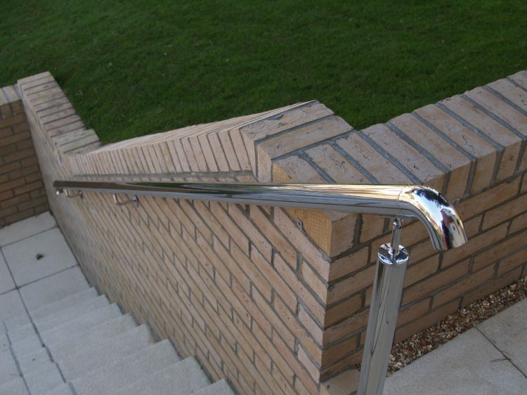 A stainless steel railing lines outside steps